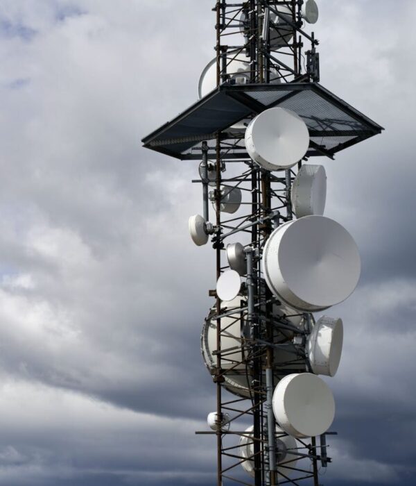 A telecommunications towers against cloudy sky background